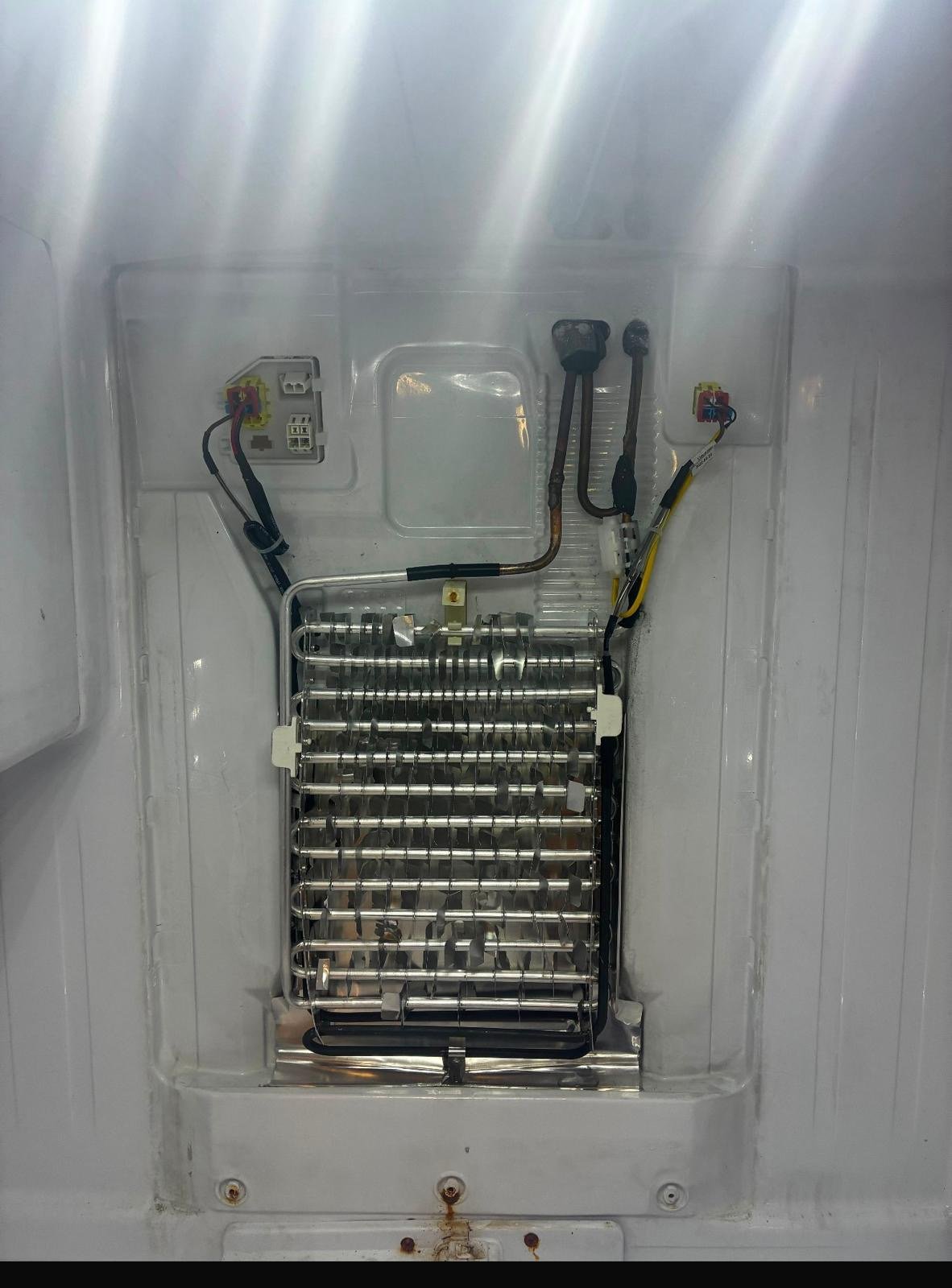 Refrigerator evaporator coil exposed during defrost repair