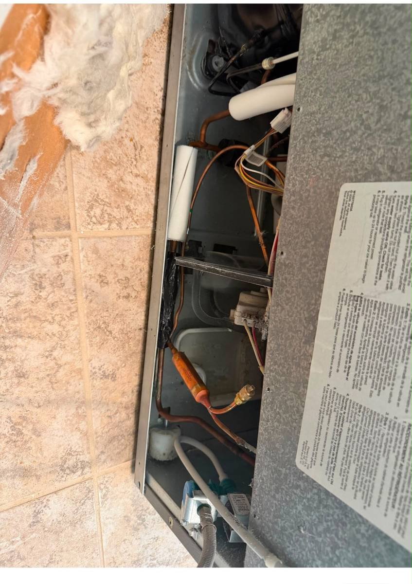 The copper lines and drier filter behind a refrigerator