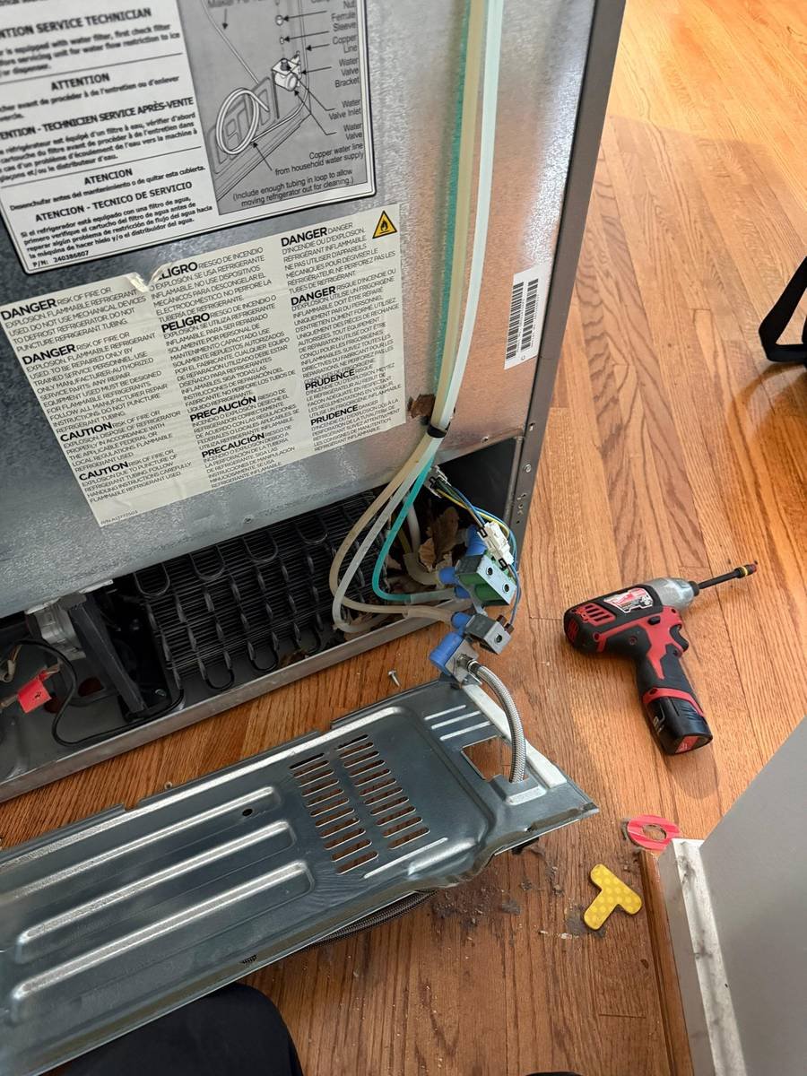 Back of a refrigerator opened for a water valve replacement
