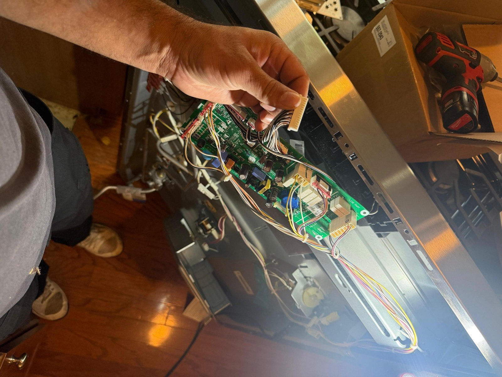Technician reconnecting a range control board harness